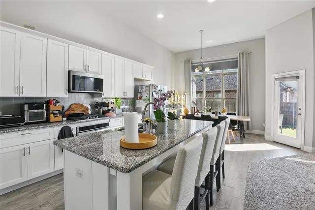 a kitchen with a table chairs stove and cabinets