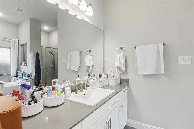 a bathroom with a sink vanity mirror and tub