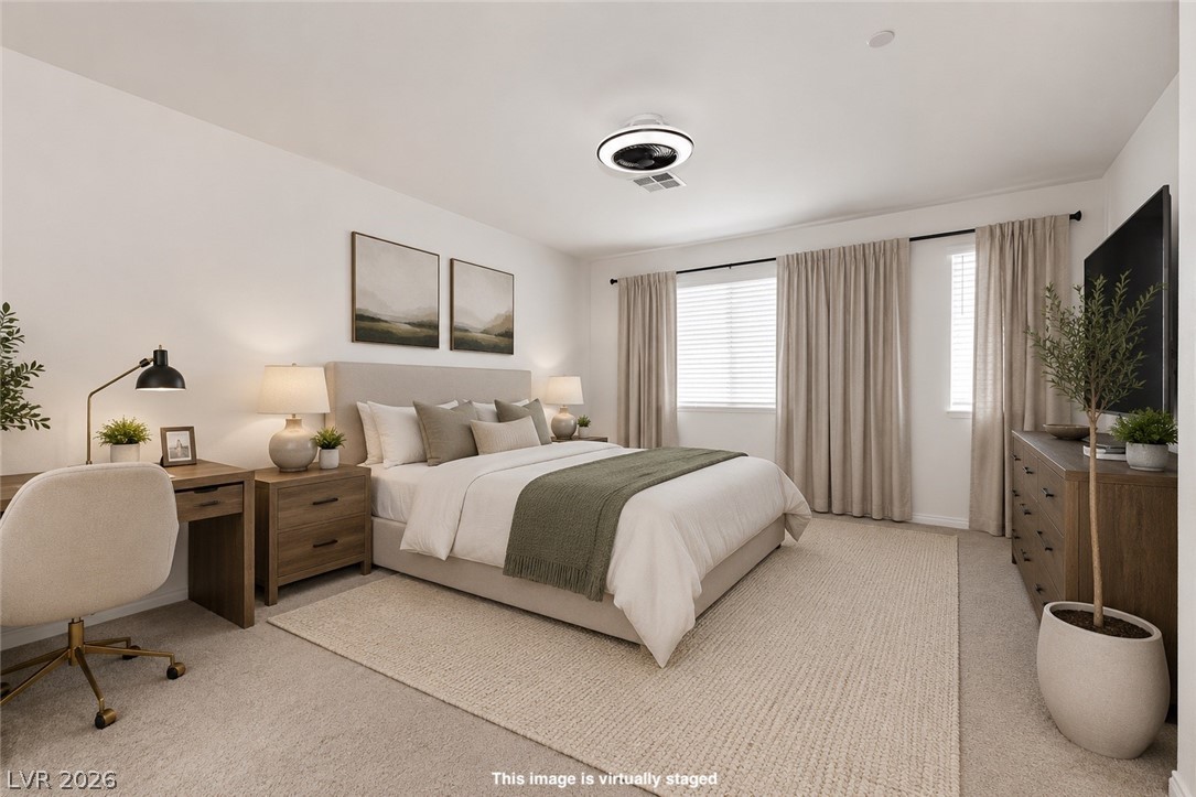 12369 Golden Wreath Road, Unit 2 Las Vegas, NV 89183 - Photo 8 of 19 A well-lit bedroom features plush carpeting, inviting comfort and tranquility.