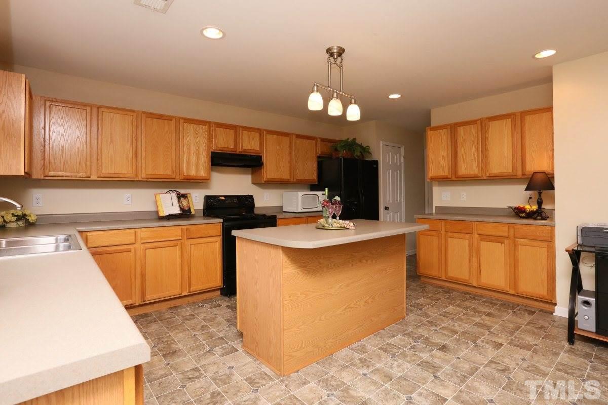 5944 Ricker Road Raleigh, NC 27610 - Photo 12 of 25 a kitchen with a sink stove and refrigerator