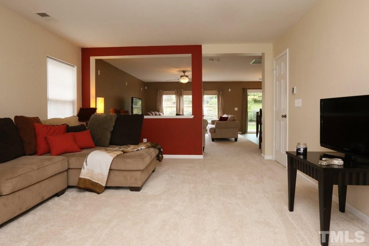 5944 Ricker Road Raleigh, NC 27610 - Photo 5 of 25 a living room with furniture and a flat screen tv