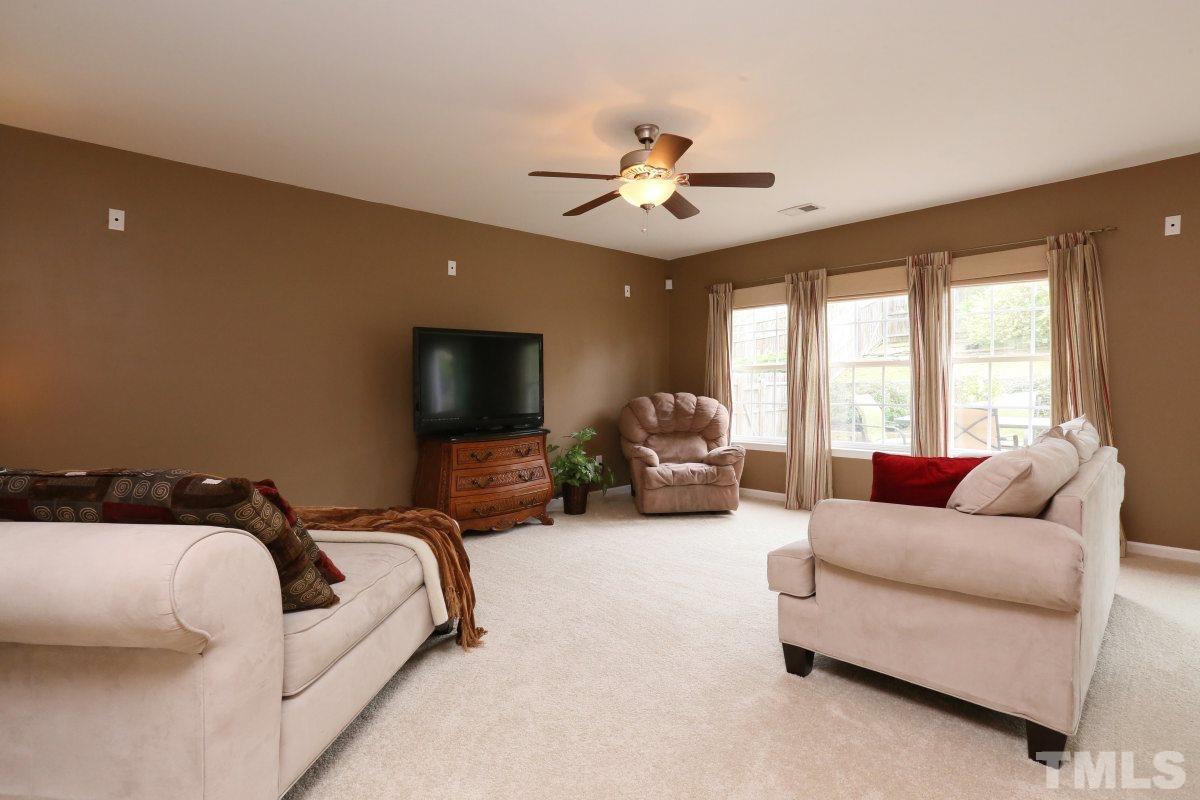 5944 Ricker Road Raleigh, NC 27610 - Photo 6 of 25 a living room with furniture and a flat screen tv