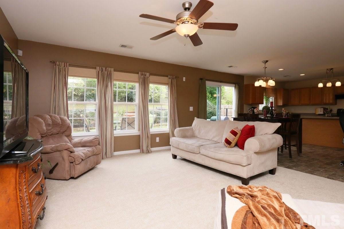 5944 Ricker Road Raleigh, NC 27610 - Photo 7 of 25 a living room with furniture ceiling fan and a large window