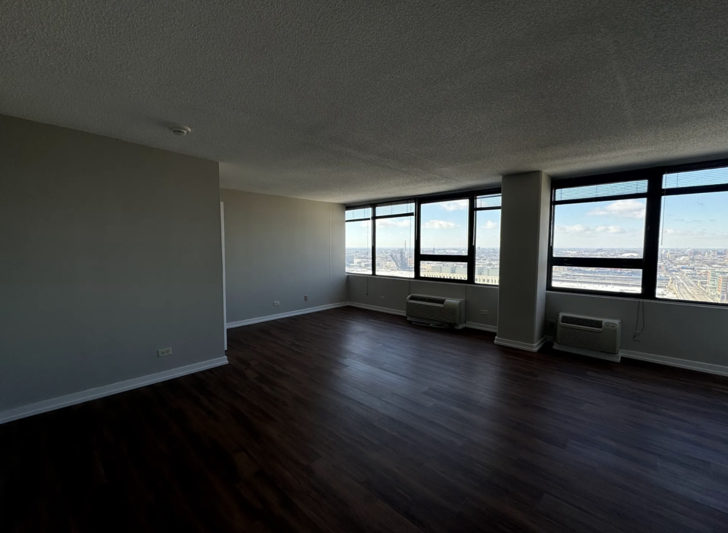 1212 South Michigan Avenue, Unit 2711 Chicago, IL 60605 - Photo 2 of 6 a view of an empty room with wooden floor and a window