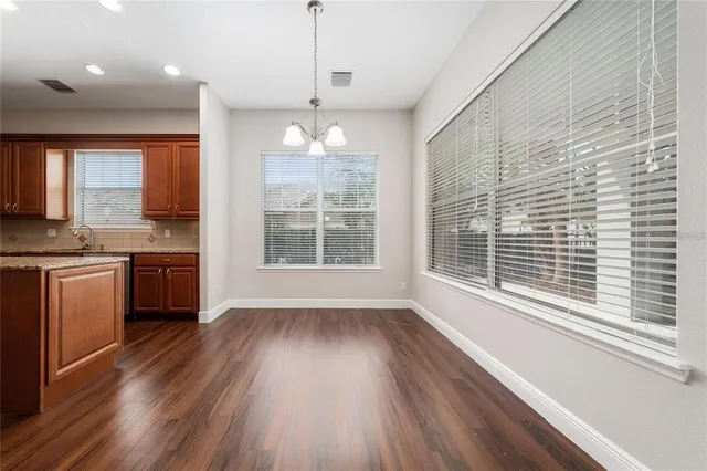 a kitchen with stainless steel appliances kitchen island granite countertop a stove a refrigerator and a wooden floors