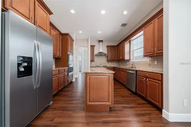 a kitchen with granite countertop wooden cabinets and a stove