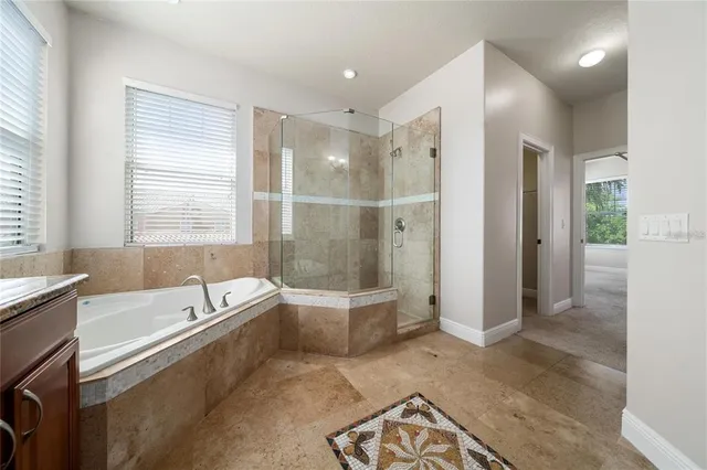 an empty room with a chandelier fan and windows