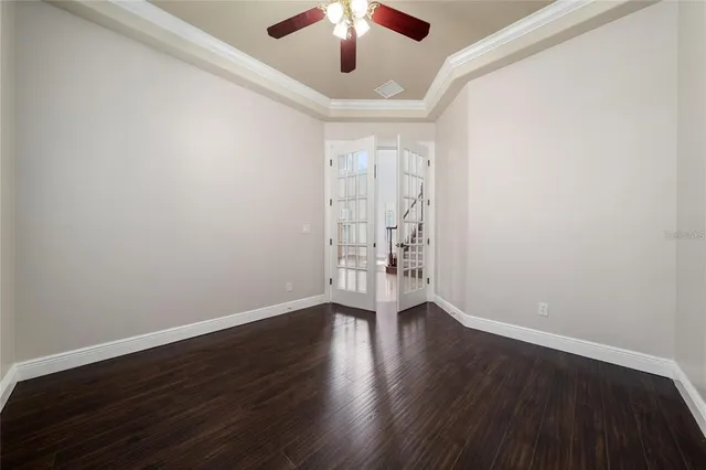 an empty room with wooden floor fireplace and windows