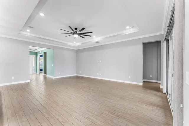 an empty room with a window and a fan