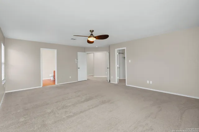 a view of an empty room with a ceiling fan