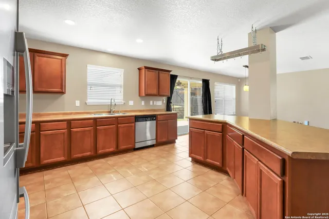a kitchen with stainless steel appliances granite countertop a sink counter space cabinets and a large window