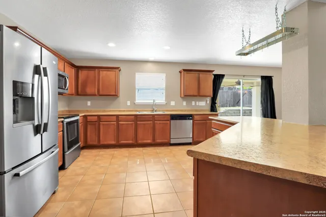 a kitchen with stainless steel appliances granite countertop a refrigerator and a sink