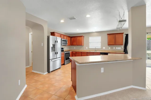 a view of a kitchen with refrigerator and a sink