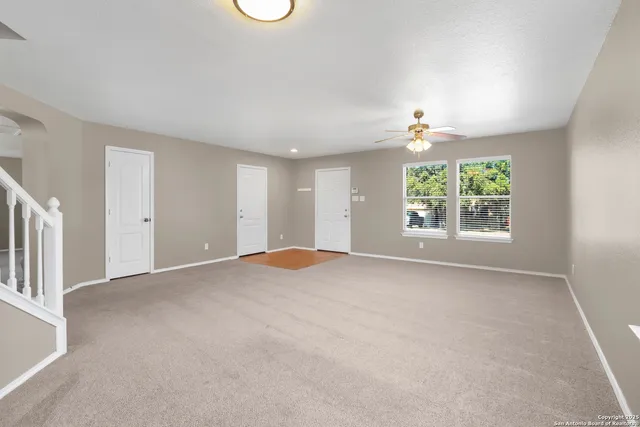 an empty room with closet and windows