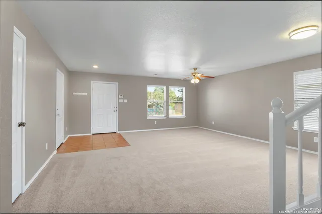 an empty room with windows and stairs