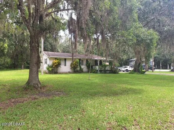 a view of house with a yard