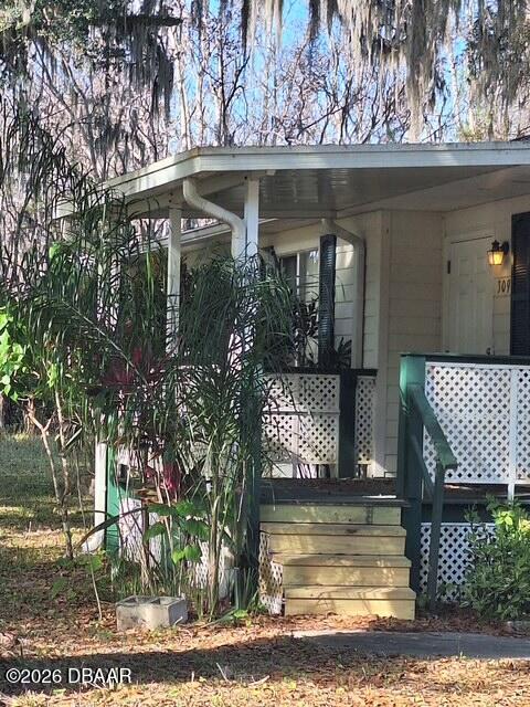 3091 Log Cabin Lane Edgewater, FL 32132 - Photo 3 of 28 a view of a small yard in front of a house with large trees