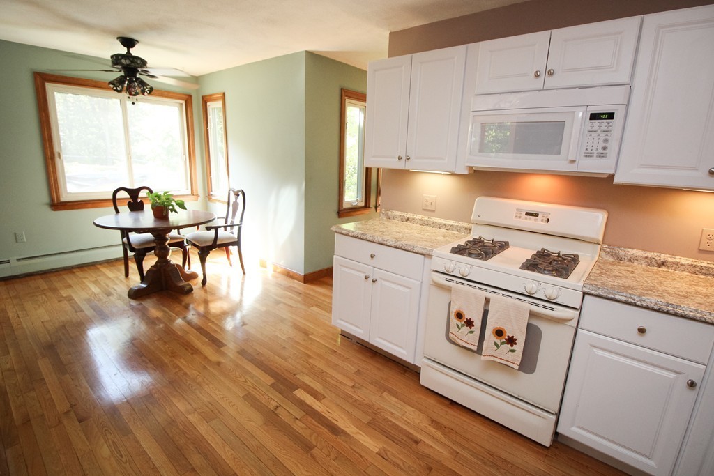 177 Glenwood Road Rutland, MA 01543 - Photo 6 of 30 a kitchen with stainless steel appliances granite countertop a stove a sink dishwasher and white cabinets with wooden floor