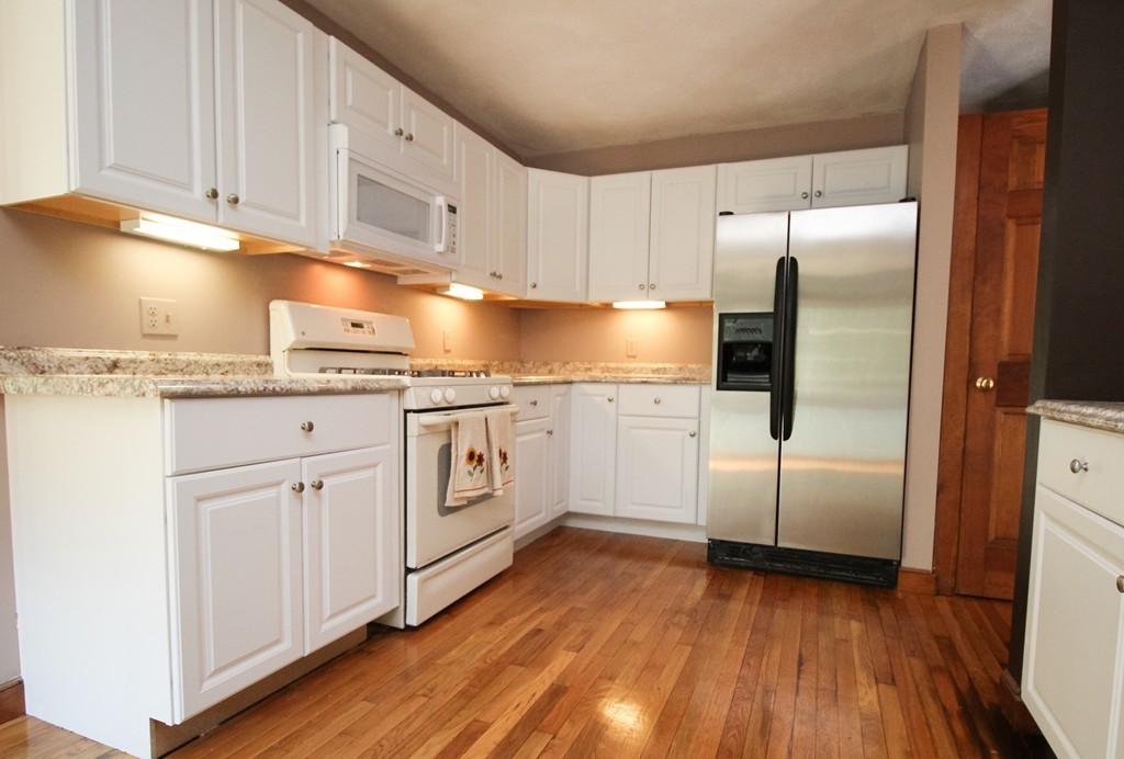 177 Glenwood Road Rutland, MA 01543 - Photo 9 of 30 a kitchen with granite countertop white cabinets and white appliances