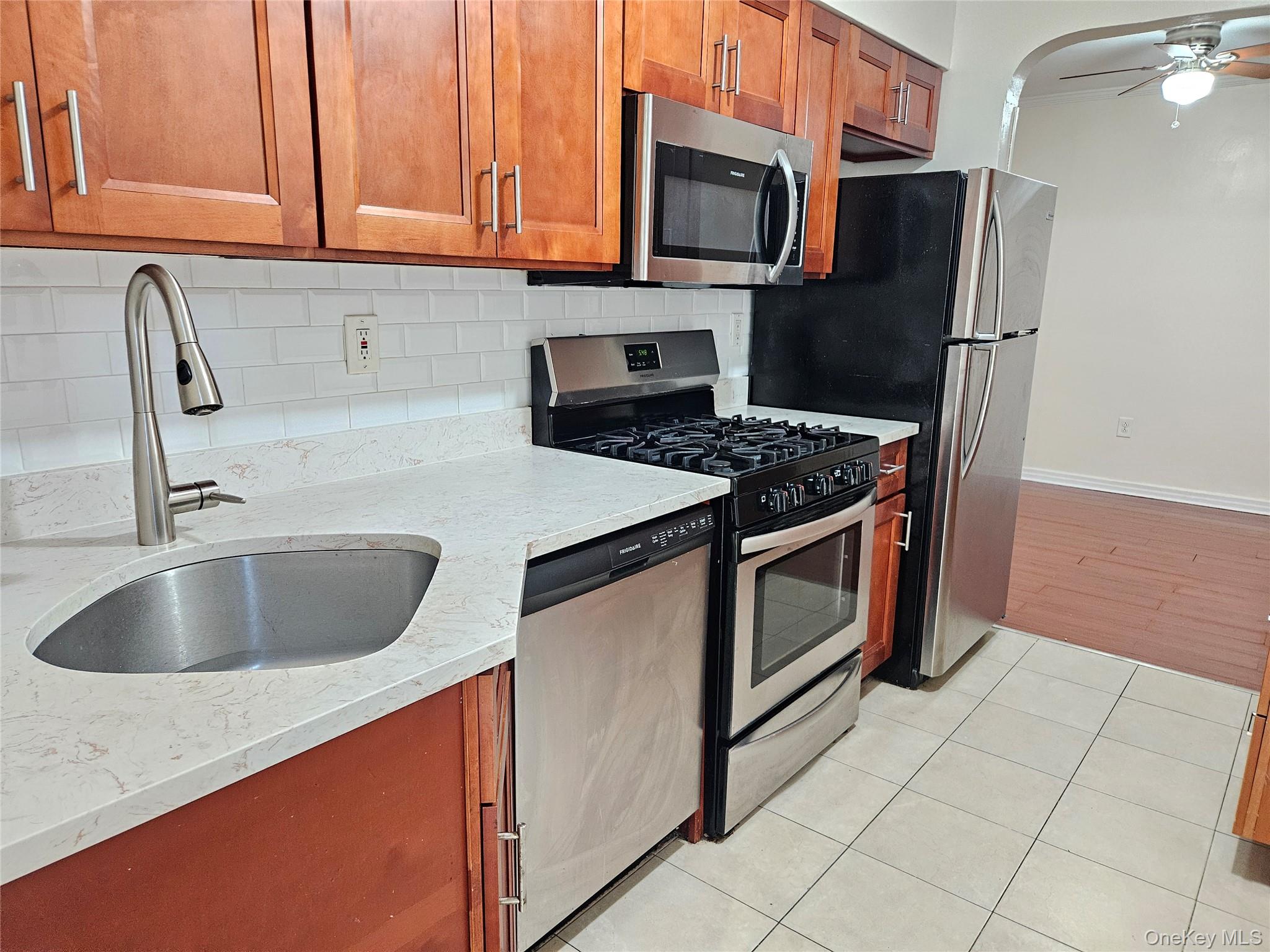 a kitchen with stainless steel appliances granite countertop a sink stove and microwave