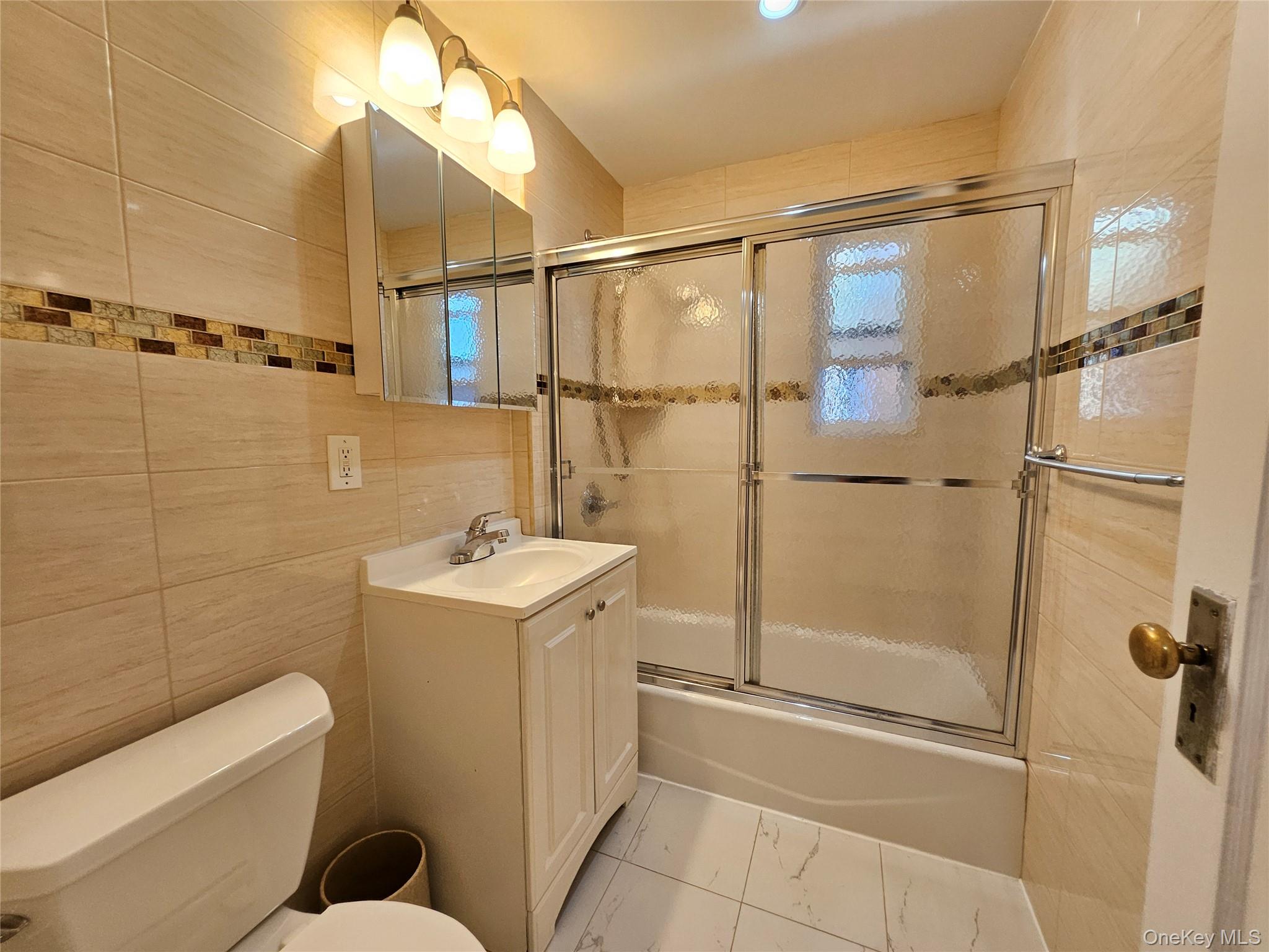 76-40 170th Street, Unit 1 Queens, NY 11366 - Photo 12 of 17 a bathroom with a sink a toilet and shower