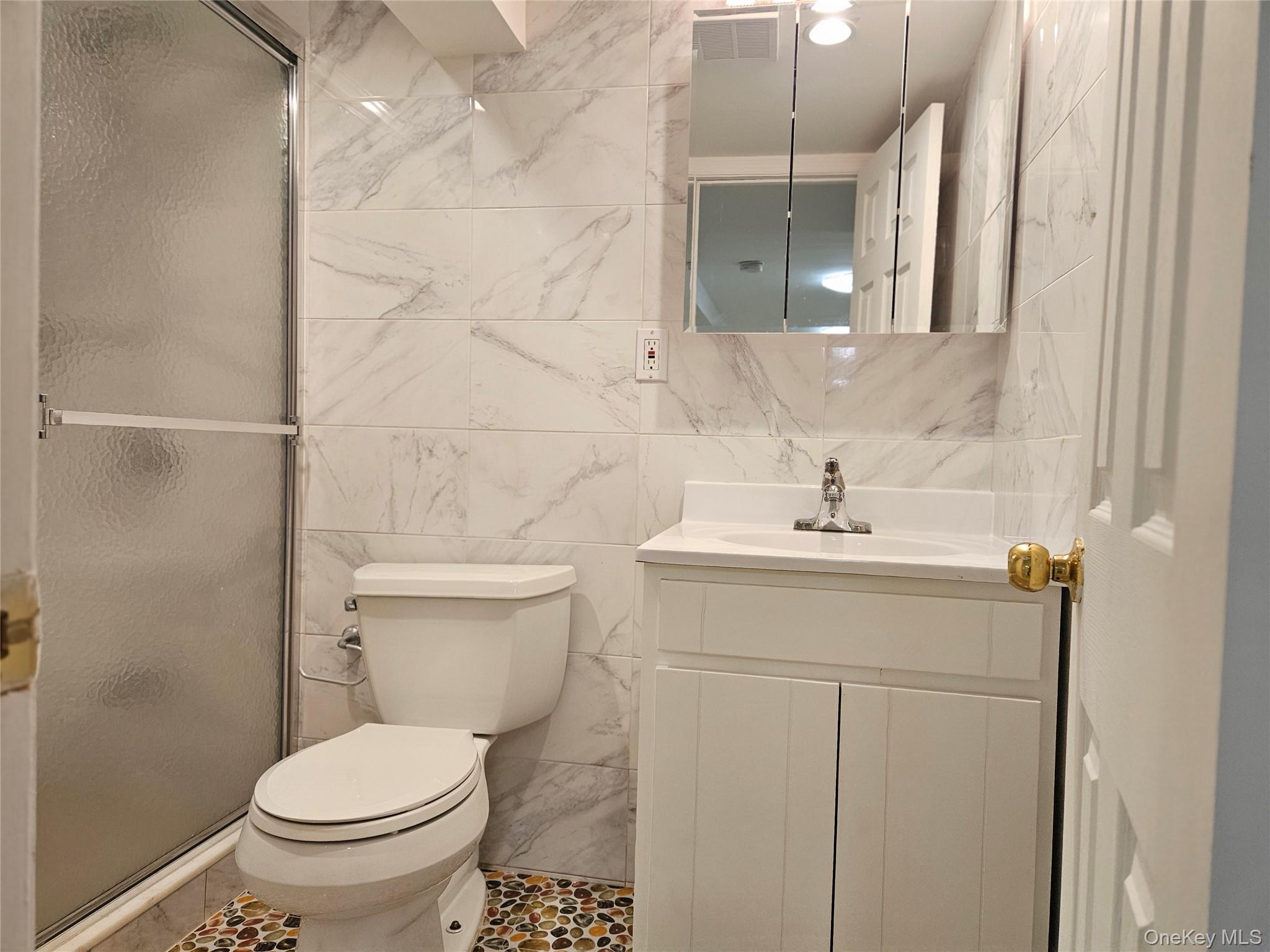 76-40 170th Street, Unit 1 Queens, NY 11366 - Photo 16 of 17 a bathroom with a sink toilet and mirror