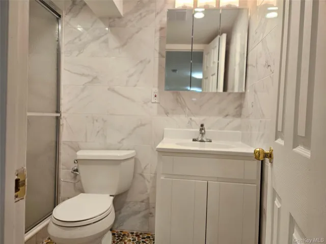 a bathroom with a toilet sink and mirror