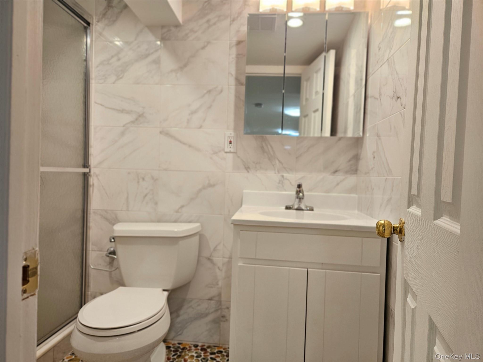 76-40 170th Street, Unit 1 Queens, NY 11366 - Photo 17 of 17 a bathroom with a toilet sink and mirror