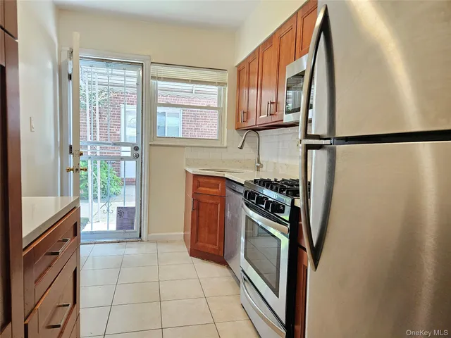 a kitchen with stainless steel appliances granite countertop a refrigerator and a stove