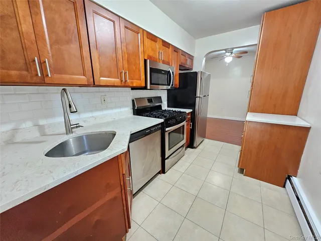 a kitchen with stainless steel appliances a sink stove refrigerator and cabinets