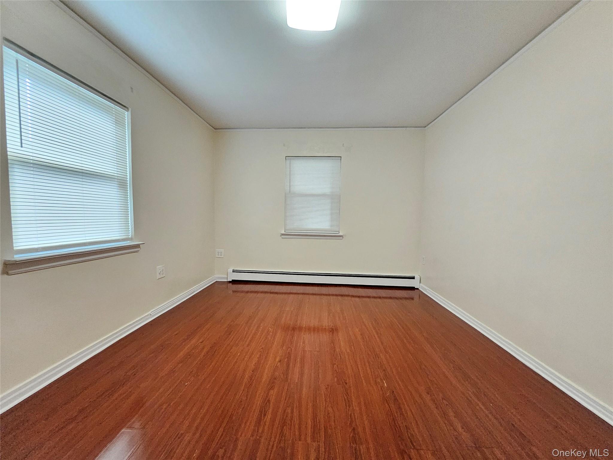 76-40 170th Street, Unit 1 Queens, NY 11366 - Photo 9 of 17 a view of a room with wooden floors and window
