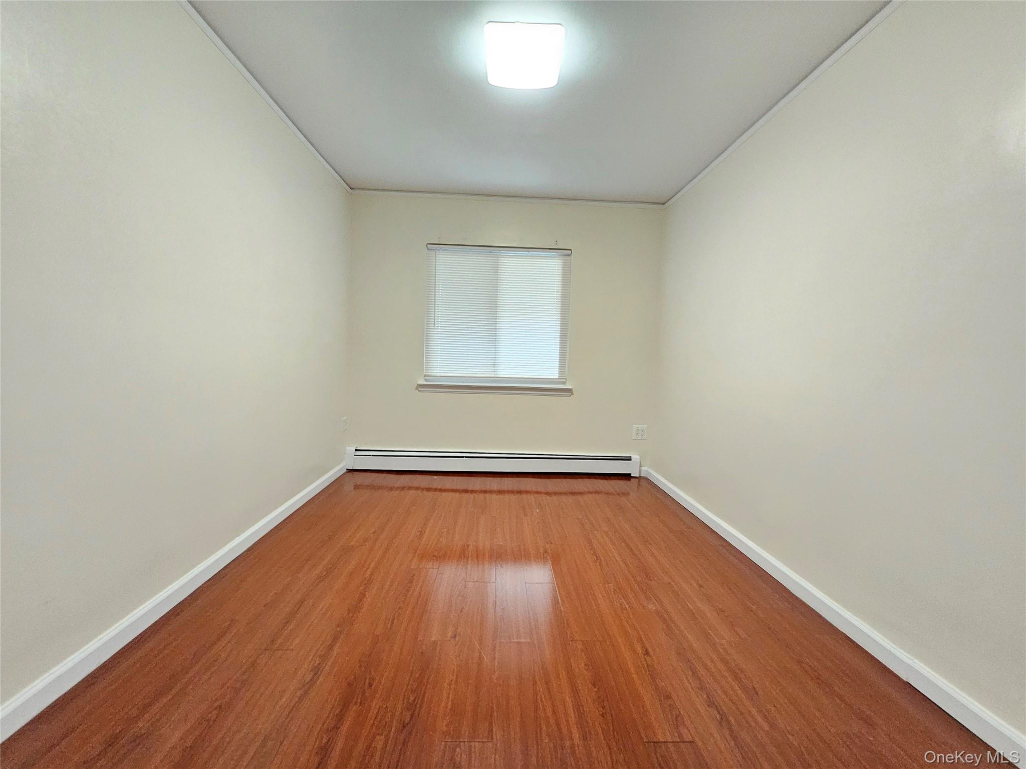 76-40 170th Street, Unit 1 Queens, NY 11366 - Photo 10 of 17 a view of a room with wooden floors and window