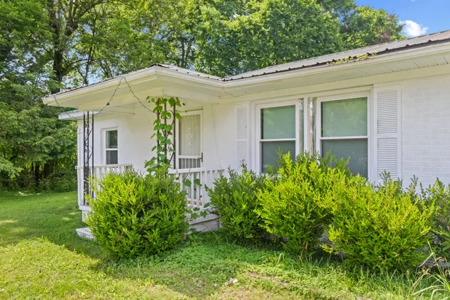 a view of a house with brick walls and a yard with plants