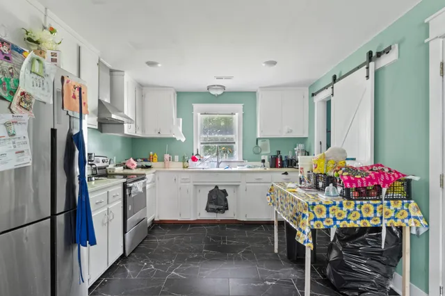 a kitchen with stainless steel appliances granite countertop a refrigerator sink and stove