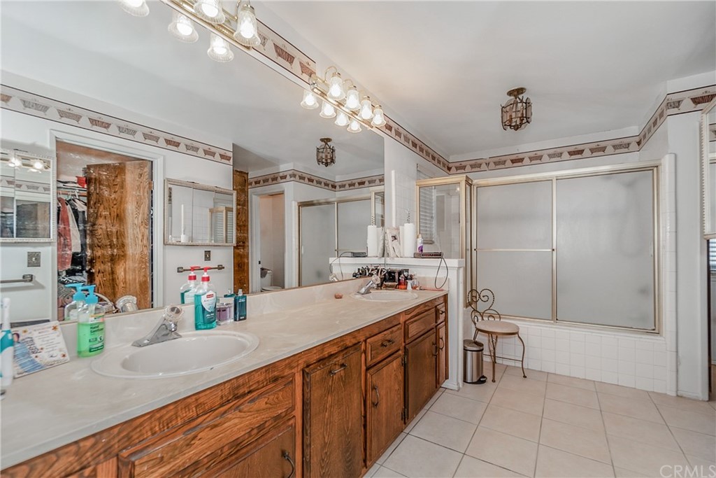 6717 Rycroft Drive Riverside, CA 92506 - Photo 17 of 28 a spacious bathroom with a granite countertop sink a mirror a bathtub and a shower