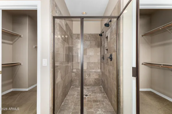 a view of an empty room with wooden floor and a bathroom