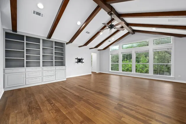 a view of empty room with wooden floor and windows