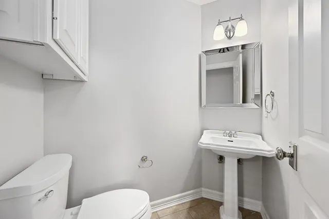 a bathroom with a toilet a sink and mirror