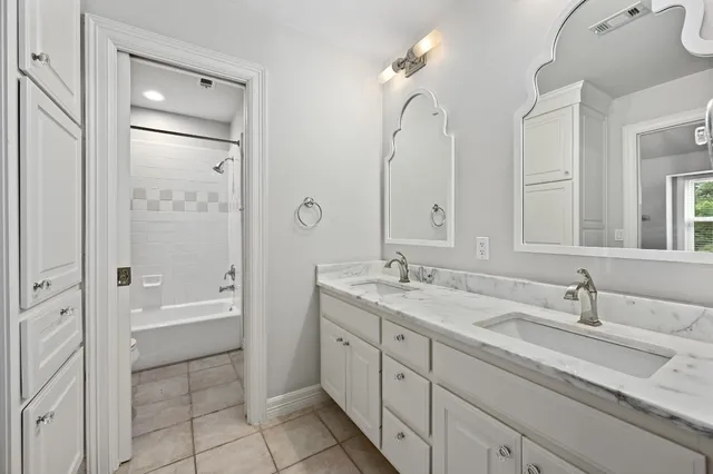 a en suite bathroom with a granite countertop sink a toilet a bathtub and shower