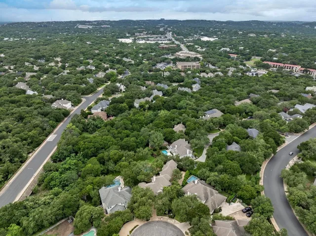 an aerial view of a residential houses covered in trees