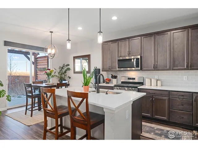 a kitchen with kitchen island granite countertop a table chairs microwave and cabinets
