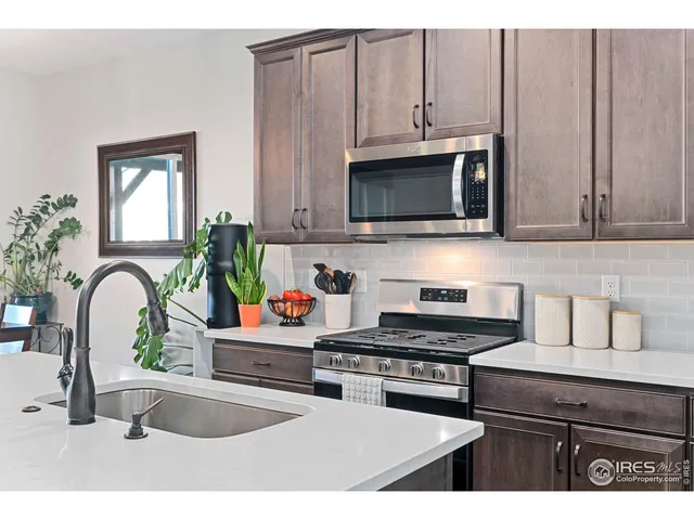 a kitchen with stainless steel appliances kitchen island granite countertop a stove a sink and a microwave