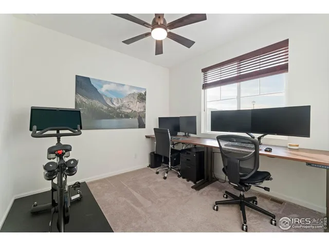 a view of a workspace with furniture and a window
