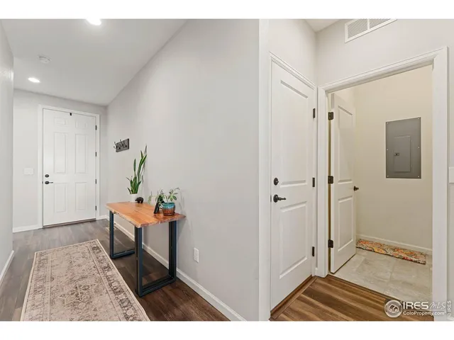 a view of a hallway and wooden floor and a bathroom
