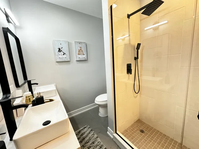 a bathroom with a granite countertop shower a toilet and a sink