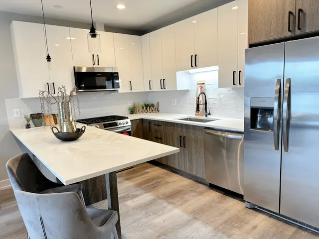 a kitchen with kitchen island granite countertop a sink a center island stainless steel appliances and cabinets