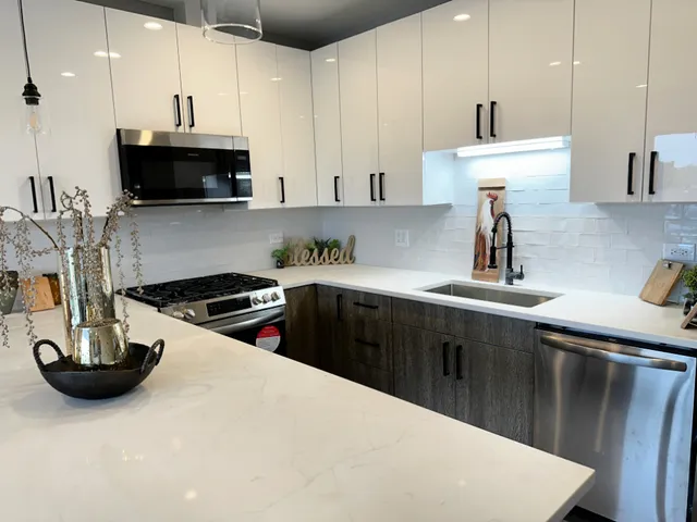 a kitchen with stainless steel appliances a sink a stove a microwave a sink a refrigerator and cabinets