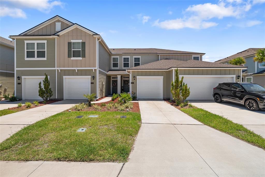 146 Redbud Road Palm Coast, FL 32137 - Photo 11 of 40 a front view of a house with a yard and garage