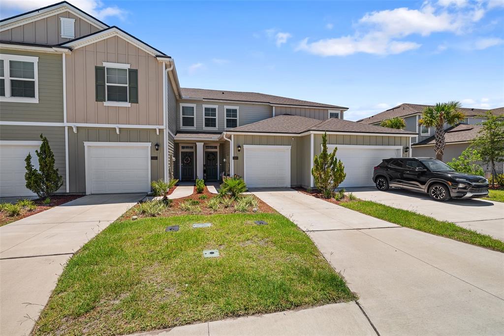 146 Redbud Road Palm Coast, FL 32137 - Photo 14 of 40 a front view of a house with a yard and potted plants