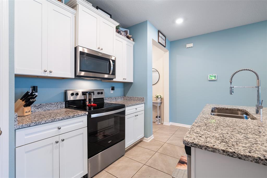 146 Redbud Road Palm Coast, FL 32137 - Photo 19 of 40 a kitchen with granite countertop stainless steel appliances a stove microwave and sink